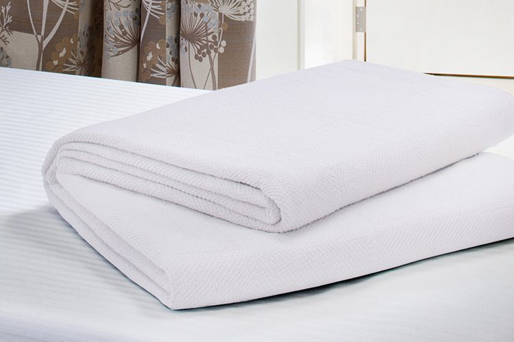 Folded Serenity blanket on hospital bed.